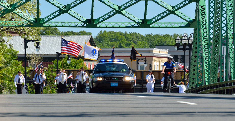 Flag bearing honor guard crossing a bridge.