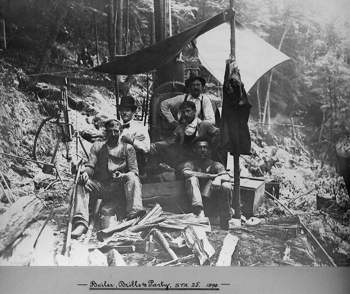 Men sitting with boiler and drills
