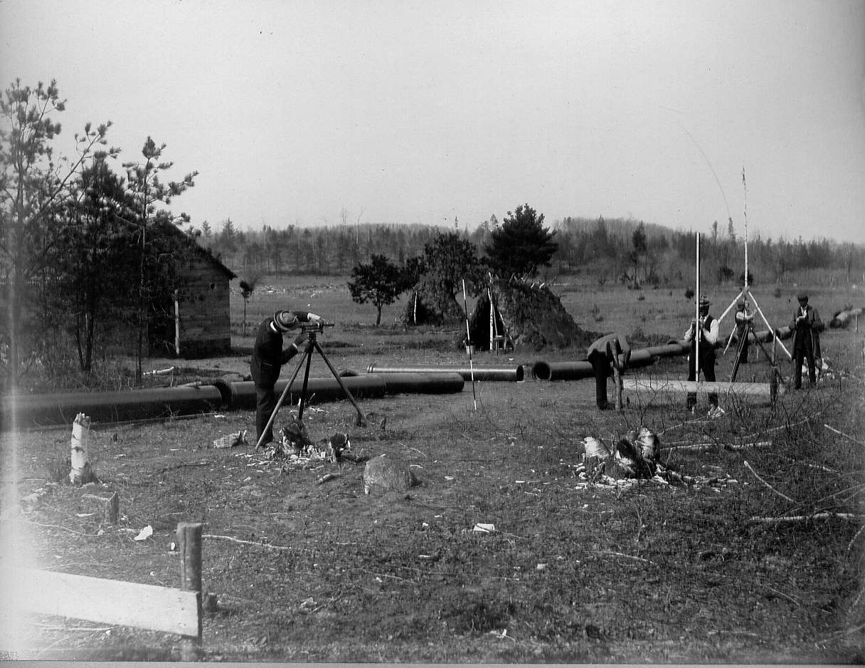 Engineering men using transits and surveying poles
